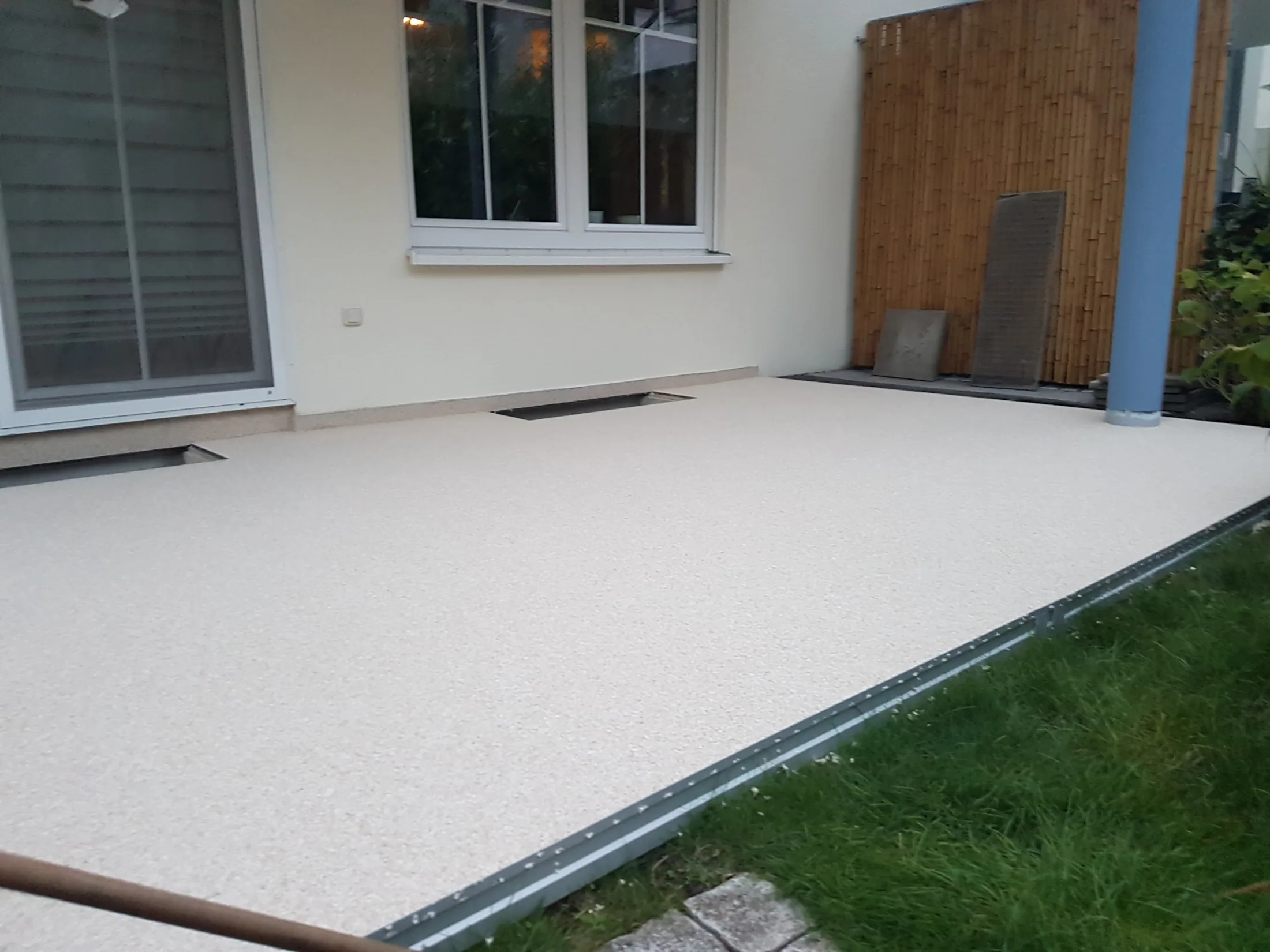 Heller Steinteppich auf einer großzügigen Terrasse am Wohnhaus